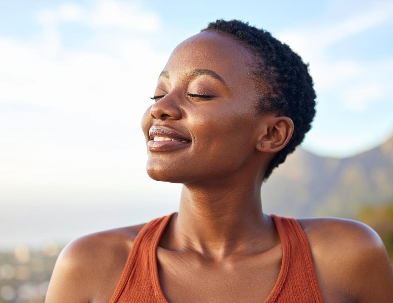 Woman, eyes closed, sun on face, peaceful